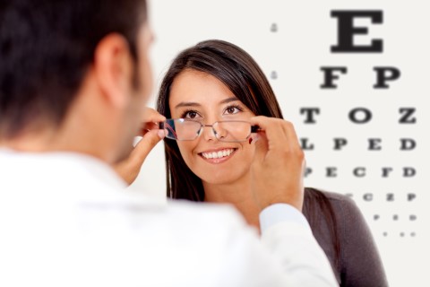 Optician putting on glasses Optician putting on glasses