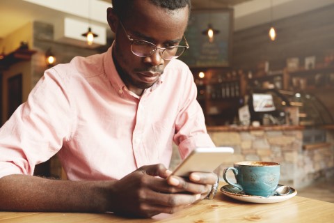 Man using smart phone in a cafe Man using smart phone in a cafe